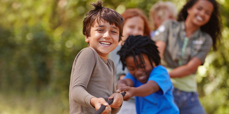 Ateliers éducatifs - Learning teamwork through play. A group of kids in a tug-of-war game.
